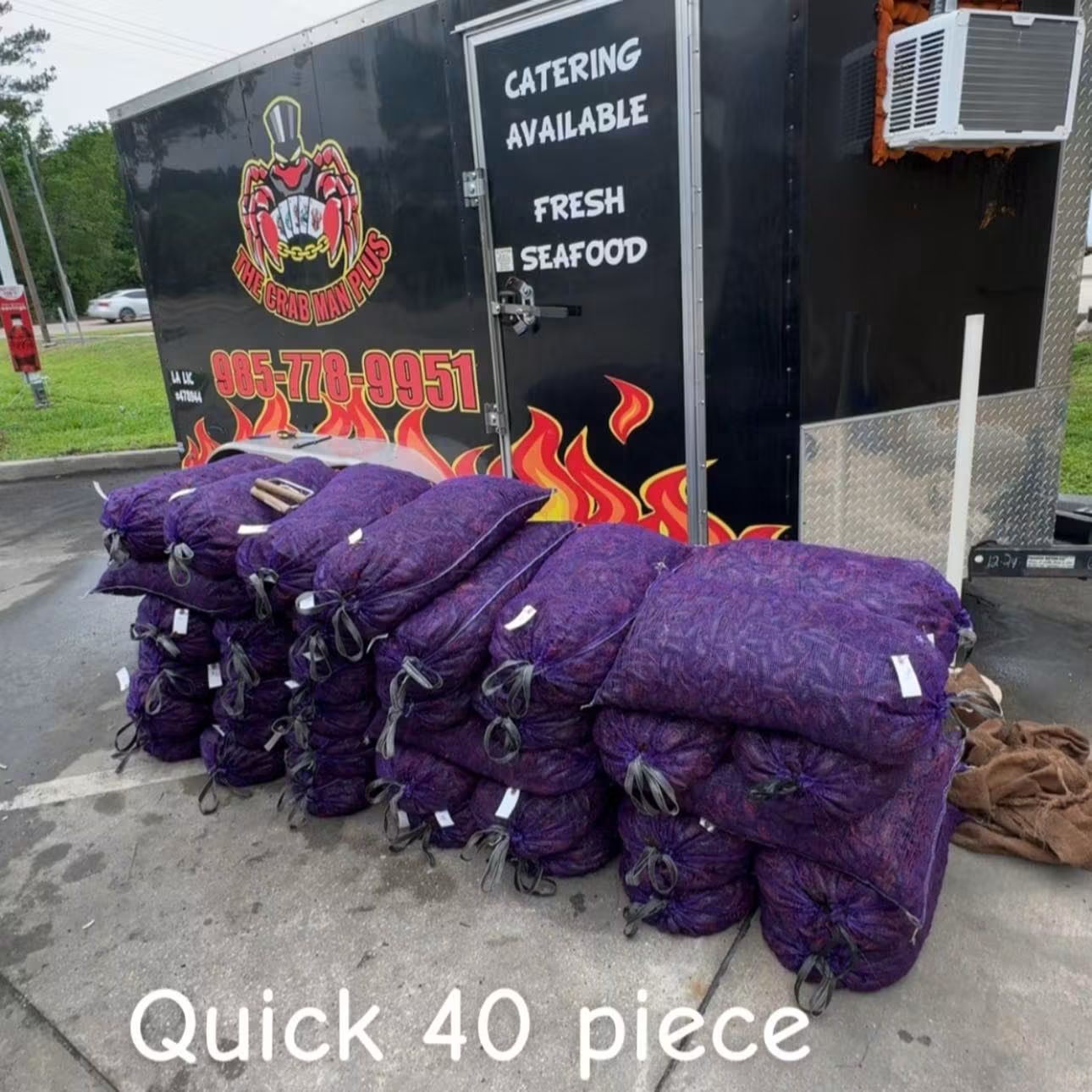 Sacks of fresh seafood staged in front of the Crab Man Plus catering trailer